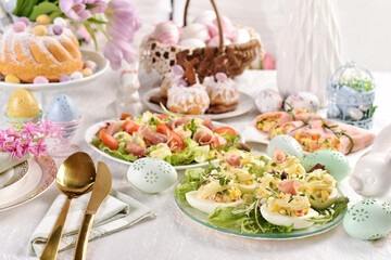 Fototapeta na wymiar Easter breakfast with fresh salad stuffed eggs and traditional pastries
