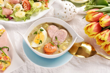 Easter table with traditional white borscht with egg and sausage