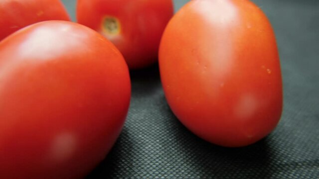 Close-up of fresh tomatoes on a dark blue table
