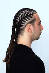 Attractive guy with braids posing in studio on isolated background. Style, trends, fashion concept.