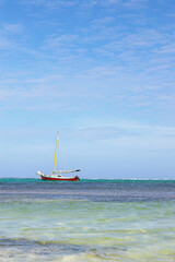 A sailboat sitting just off shore along the coast in Belize