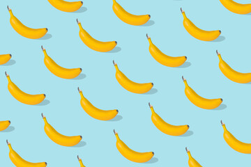 Obraz na płótnie Canvas Trendy Summer food pattern made with fresh banana fruit on bright blue background
