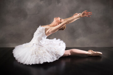 Naklejka premium Ballerina in white tutu, leaning back like a swan.