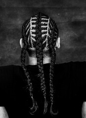 Attractive guy with braids posing in studio on isolated background. Style, trends, fashion concept.