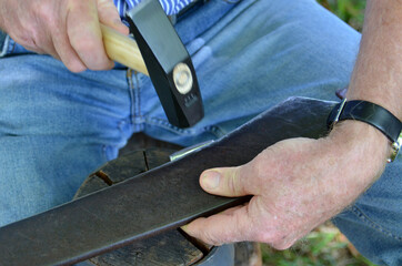 Sensendengeln im Salzkammergut, Oberösterreich, Österreich, Europa - Scythe sharpening in the...