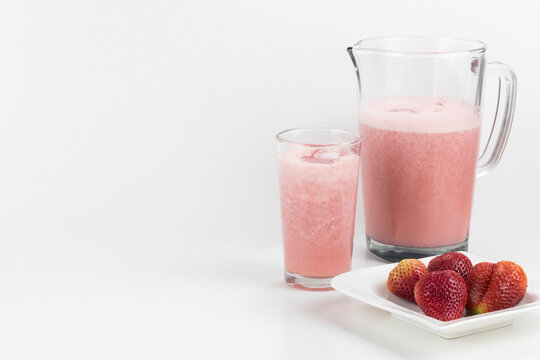 concepto aislado de jugo de fresa en leche sobre una mesa blanca