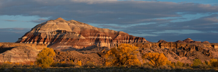 USA, Utah. Autumn cottonwoods and sandstone formations at sunset, Capitol Reef National Park.