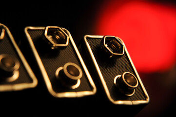 Macro view of 9-volt battery terminals, showing snap connectors in a row, illustrating standard...