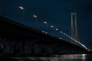 Night bridge in Kiev, view from the water, beautiful sky and shining lanterns.
