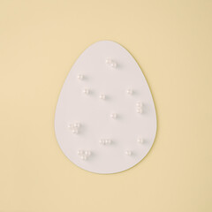 2021 Easter egg shape with white pearls on beige background. Minimal holiday concept. Flat lay. .