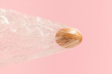 Fototapeta premium Natural Easter egg flying with foil bag on pink background. Bullet egg or airplane broke throught the sound barrier. Creative holiday concept.