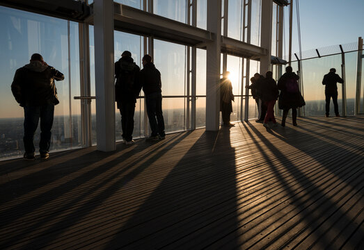 Group of tourists photographing from skyscraper rooftop, London, UK