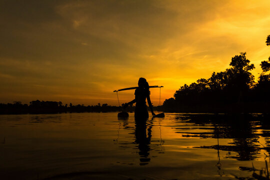 Woman collecting water at sunrise, Srah Srang reservoir, Angkor Wat Complex, Siem Reap, Cambodia