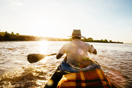 Rear view of man rowing boat onTsiribihina River, Madagascar, Africa