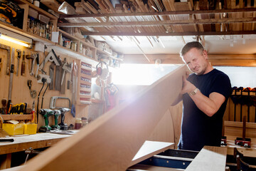 Craftsman preparing planks of wood in workshop