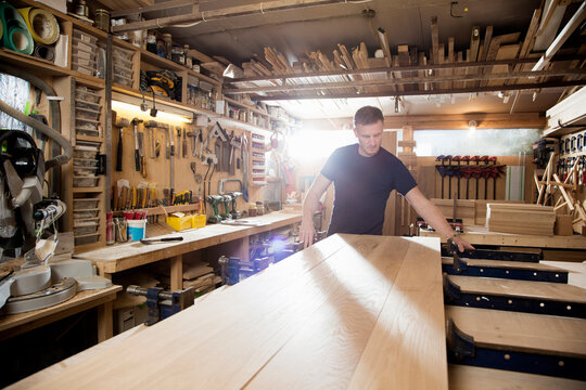 Craftsman preparing planks of wood in workshop