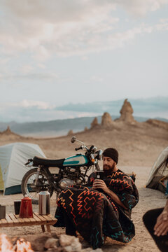Motorcyclist road trippers around camp fire, Trona Pinnacles, California, US