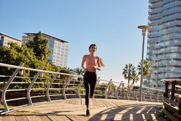 Woman jogging in city park, Barcelona, Catalonia, Spain