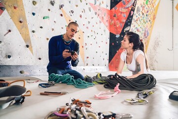 Climber friends on crash pad working with and learning about climbing equipment