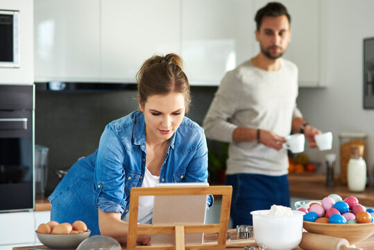 Couple drinking coffee and using digital tablet in kitchen