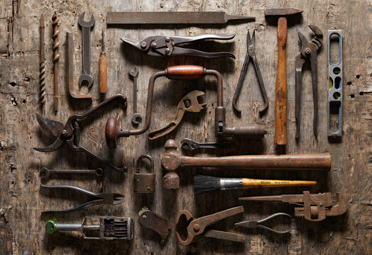 Variety of vintage hand tools on wood, overhead view