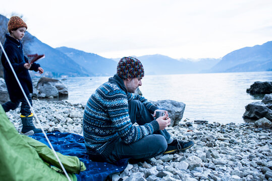 Father and son camping by lakeside, Onno, Lombardy, Italy