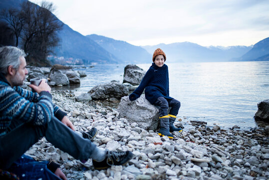 Father and son on lakeside, Onno, Lombardy, Italy