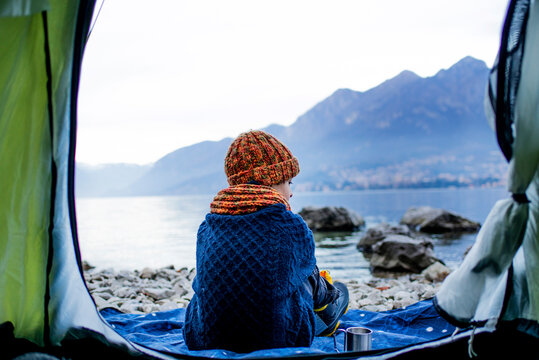 Boy sitting on blanket by tent, rear view, Lake Como, Onno, Lombardy, Italy