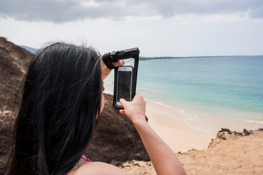 Woman taking photo on beach, Makena Beach, Maui, Hawaii