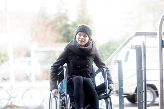 Woman in wheelchair moving up ramp