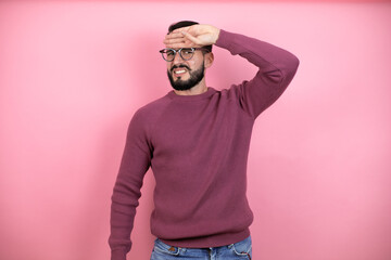 Handsome man wearing glasses and casual clothes over pink background touching forehead for illness and fever, flu and cold, virus sick
