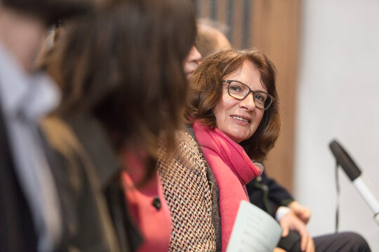 Senior woman sitting within a row of people, side view portrait