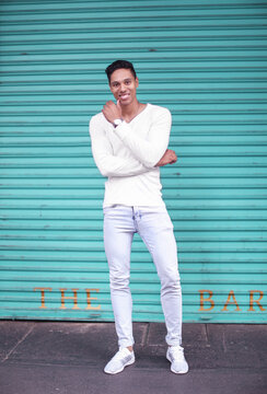 Young man standing in front of turquoise shutters, portrait, Cape Town, Western Cape, South Africa