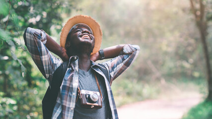 Happiness African man traveler with backpack standing and relaxing freedom in the forest.16:9 style