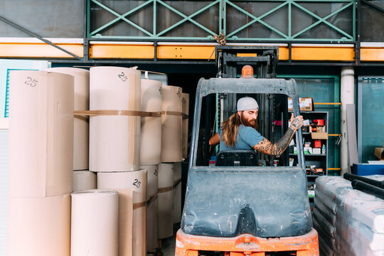 Man reversing fork lift out of warehouse