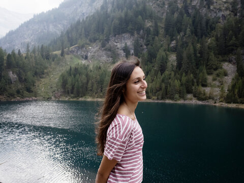 Woman enjoying view by lake, Antronapiana, Piemonte, Italy