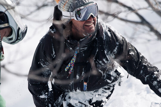 Male snowboarder covered in snow on mountainside, Alpe-d'Huez, Rhone-Alpes, France