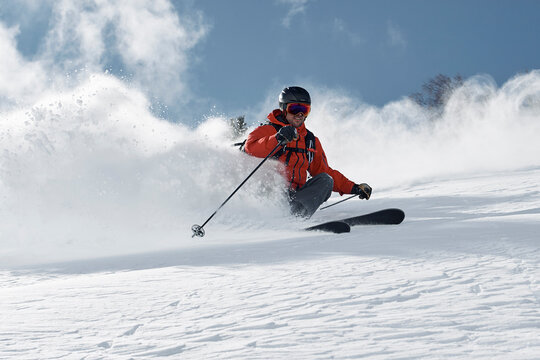 Male skier skiing down mountainside, low angle view, Alpe-d'Huez, Rhone-Alpes, France