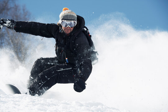 Male snowboarder speeding down mountainside, Alpe-d'Huez, Rhone-Alpes, France
