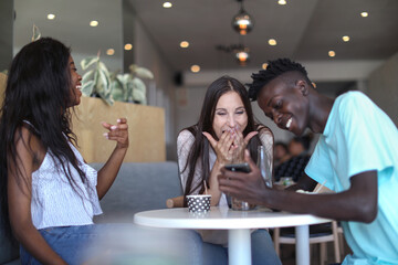 Friends using smartphone in ice cream parlour