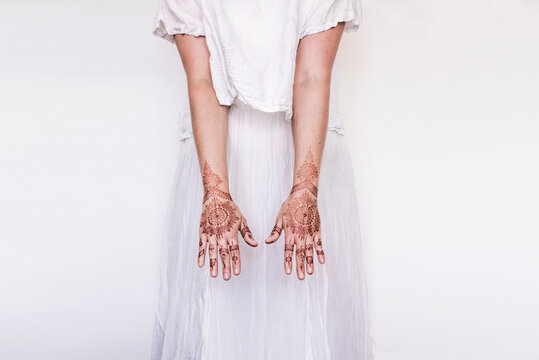 Woman in white dress with henna tattoo on hands