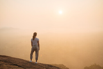 Woman watching sunrise from Pidurangala, Sigiriya, Central Province, Sri Lanka