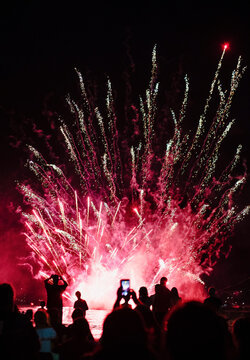Group of people watching fireworks display at night