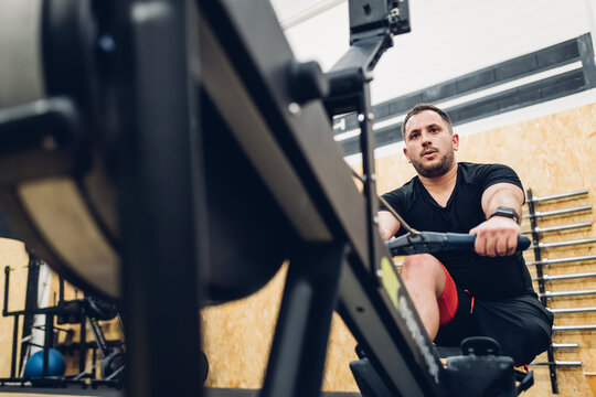 Man with disability using rowing machine in gym