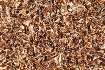 A heap of small pieces of chopped brown plastic bottles. View from above. Closeup