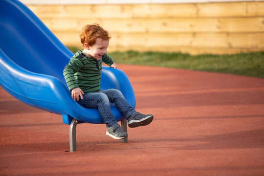 Boy playing on slide in playground