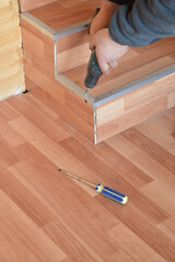 screwdriver in hands screw a metal corner