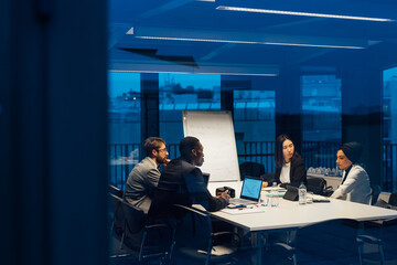 Businessmen and women having discussion during conference table meeting
