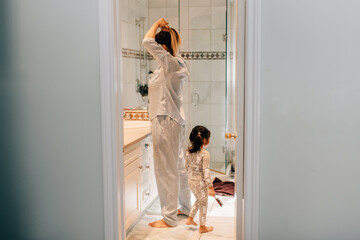 Girl and mother getting ready in bathroom