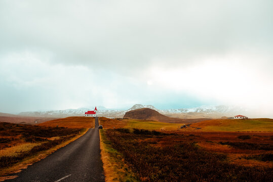 Car stopped on road leading towards house with red roof, Stykkishólmur, Snafellsnes- og Hnappadalssysla, Iceland